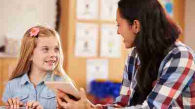 A teacher helps a student one on one, a smart strategy to help adhd students.
