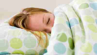 ADHD and sleep advice for adults like this woman sleeping on her side in bed.