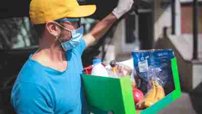 autism resources - a man carrying groceries while wearing a face mask and gloves