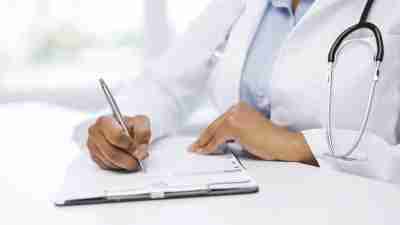 Doctor writing prescription for ADHD child on notepad
