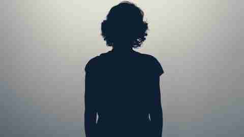Female silhouette with short, curly hair against a faded grey background.