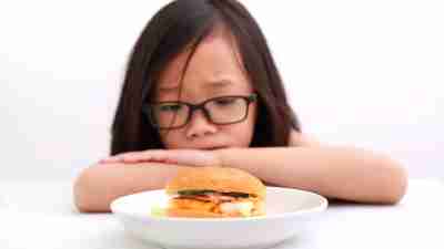 picky eating - child looking concerned over a dish