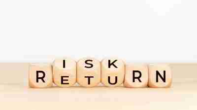 Risk Return concept. Wooden block with text on table. Copy space