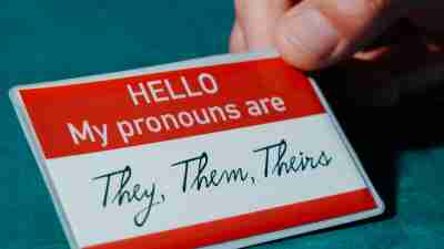 Name tage which reads "My pronouns are they, them, theirs"