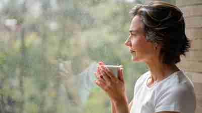 Thoughtful senior woman looking out the window wondering whether she should pursue an ADHD diagnosis as an older adult after age 50