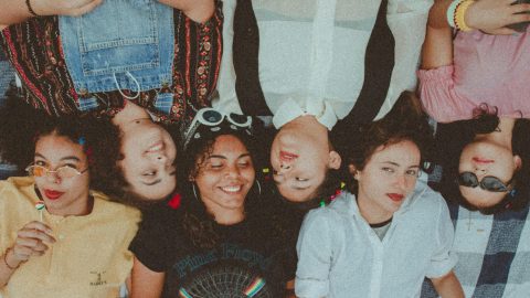 A photo of a group of young women lying head to head, facing opposite directions.