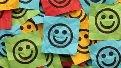 Colorful crumpled adhesive notes with smiling faces. that symbolize emotional regulation